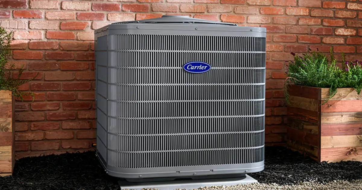 residential carrier ac unit in front of a brick all