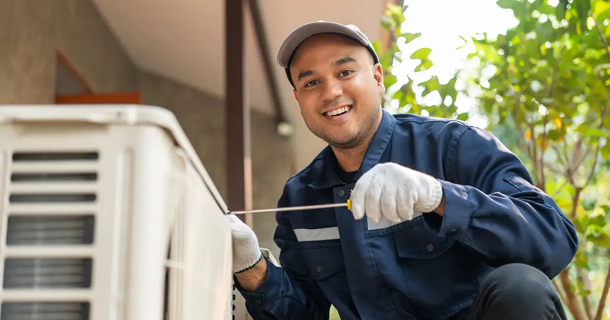 HVAC tech working on an outdoor AC unit