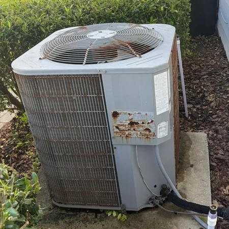 Rusty outdoor AC unit in Jacksonville, Florida. Caption reads "BEFORE."
