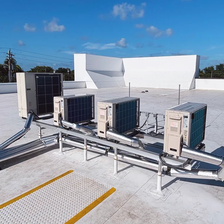 Row of commercial VRF/VRV outdoor heat pump units mounted on raised roof stands.