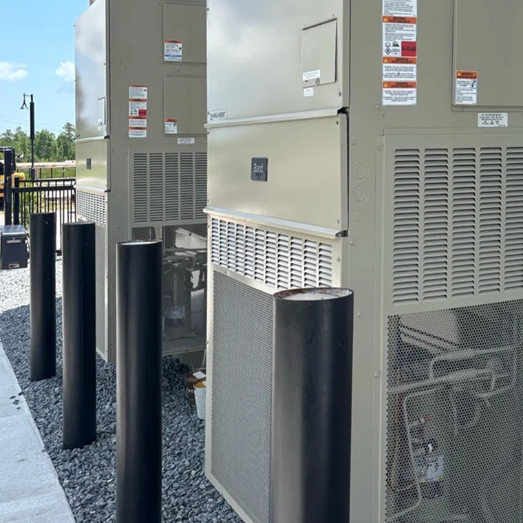 Large Bard wall-mount commercial HVAC units installed outdoors behind protective safety bollards.