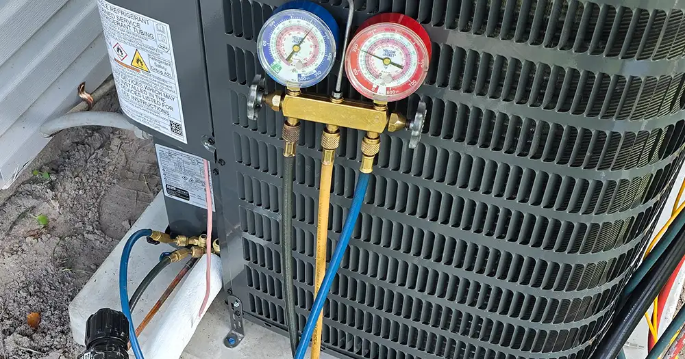 Refrigerant pressure gauges connected to an outdoor AC unit during HVAC maintenance in the Orlando area.