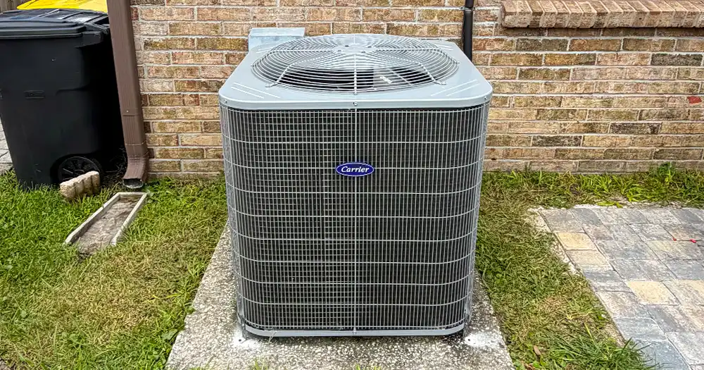Carrier outdoor AC condenser installed beside a brick home in Jacksonville.