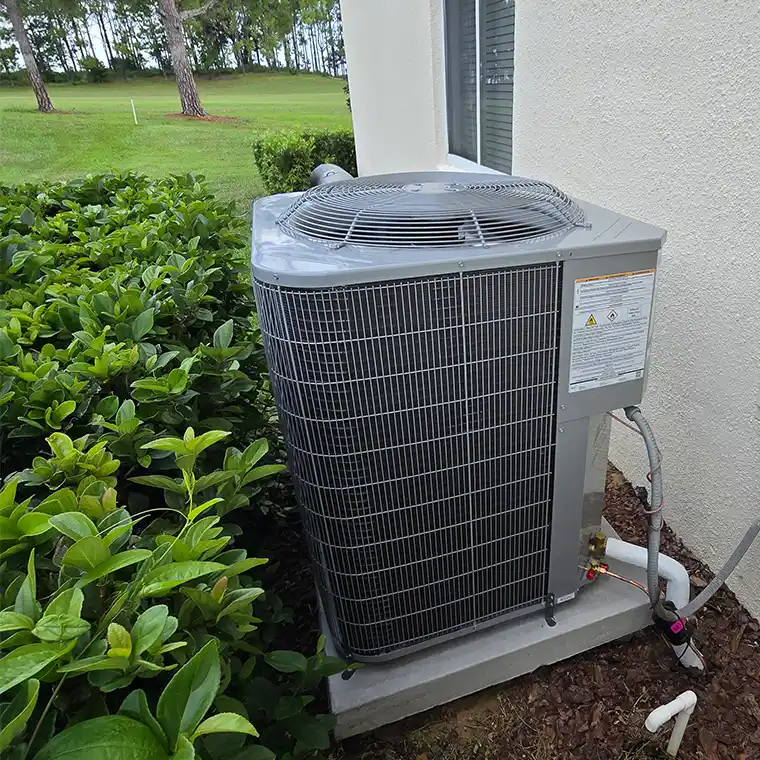 Outdoor AC condenser installed beside a home after an AC replacement in Clermont.