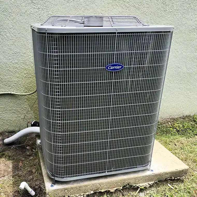 New Carrier AC outdoor unit installed on a concrete pad.